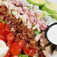 Cobb Salad · Crisp romaine lettuce covered by rows of diced tomatoes, fresh avocado, crumbled bacon, egg,...