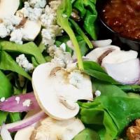 Spinach Salad · Fresh spinach, walnuts, sliced mushrooms, onions, and blue cheese crumbles. Served with a si...