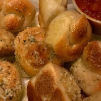 Garlic Knots (10) · 10 strips of pizza dough tied in a knot baked and then topped with garlic/oil and mix of ore...