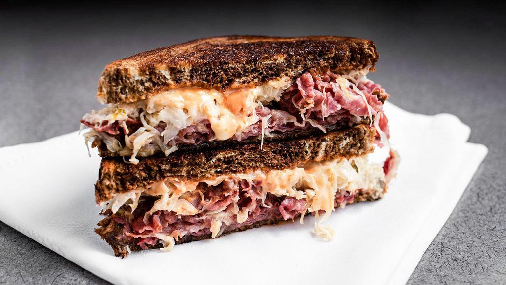 Rockefeller Reuben · Pastrami, corned beef, or turkey, Swiss, sauerkraut, spicy mustard or Russian dressing, butter, on rye, and served hot. Served with a pickle spear and your choice of potato salad, pasta salad, fruit salad, coleslaw or chips.