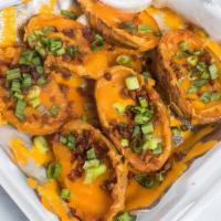 Loaded Potato Skins · Six potato skins fried crisp loaded with cheddar cheese, crispy bacon and chopped green onio...