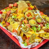 Super Nachos · Corn tortillas topped with homemade chili, cheddar cheese and jalapenos. Served with sour cr...
