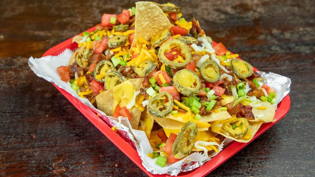 Super Nachos · Corn tortillas topped with homemade chili, cheddar cheese and jalapenos. Served with sour cream.