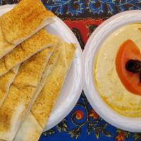 Hummus And Pita · Fresh daily-made chickpeas dip topped with kalamata olive, paprika, and olive oil. Served wi...