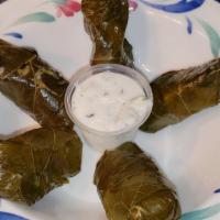 Stuffed Grape Leaves · Cooked grapevine leaves stuffed with rice and spices, served with a side of cucumber sauce, ...