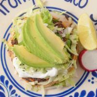 Sopes · A small corn dough cake filled with your choice of meat topped with lettuce, onions, and cil...