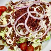 Wedge Salad · Iceberg, bacon, tomatoes, red onion, blue cheese dressing, and blue cheese crumbles.