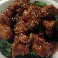 Sesame Chicken · Chicken chunks in house special sauce with sesame seeds on the top and surrounded by broccoli.
