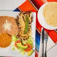 Platillo De Carne Asada · Steak served with nopal grilled onions, rice, beans, salad and tortillas.