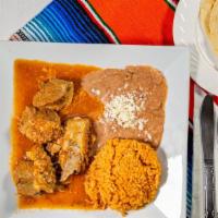 Guisado De Puerco · Fried pork cooked in spicy tomato sauce served with rice, beans and tortillas.