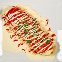 Burrito El Sol · Served with carnitas and beans topped with cheese sauce, red sauce, Mexican cream, tomatoes,...