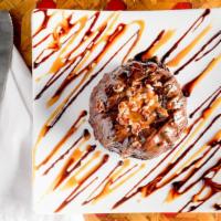 Caramel Turtle Chocolate Cake · Moist and fudgy chocolate cake enrobed in chocolate, topped with toasted pecans and filled w...
