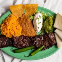 Carne Asada · Grilled skirt steak in chipotle marinade, served with tortillas, sour cream , guacamole, ric...