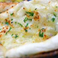 Garlic Naan · Fresh made leavened dough led with garlic and baked in a traditional coal oven.