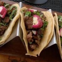 Mexican Street Tacos (3) · Corn tortilla, meat, onion, cilantro, radish, lime, salsa roja, and salsa verde.