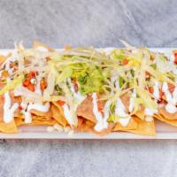 Nachos · Nachos served with corn chips, pinto beans, lettuce, pico de gallo, avocado, and drizzled wi...