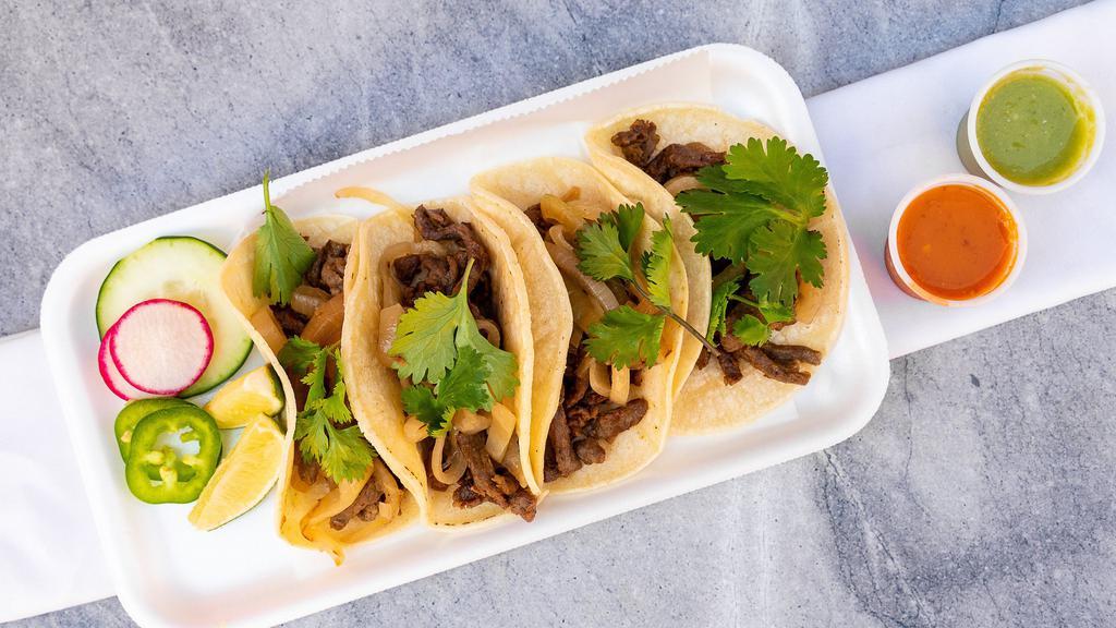 Flank Steak Tacos · 4 tacos served in corn tortilla toped with caramelized onions and cilantro.