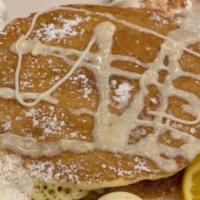 Pancakes Short Stack · Two pancakes served with butter, whipped cream, and powdered sugar.