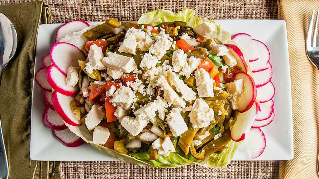 Ensalada De Nopales · Mexican cactus salad with tomatoes, onions, cilantro, radish, fresh cheese and chips.
