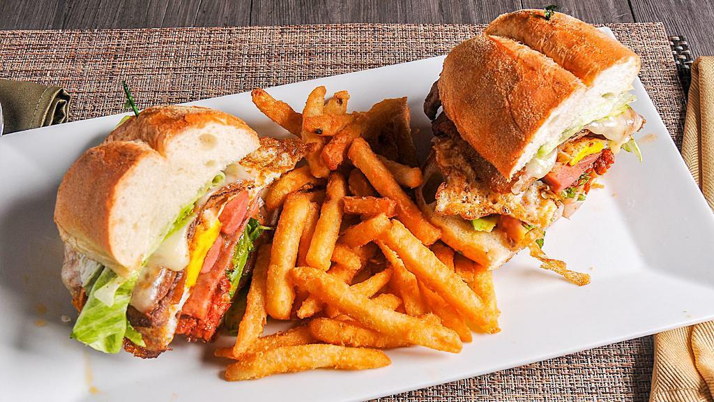Torta Don Barriga · Breaded beef or breaded chicken, ham, turkey franks, scrambled eggs and chorizo with mayonnaise, fried beans, onions, lettuce, tomato, avocado, melted cheese and choice of jalapenos or chipotle and a side of fries.