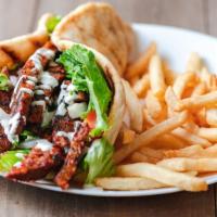 Lamb Gyro Combo · Lamb gyro on pita bread, Lamb seared over charcoal grille topped with Green Leaf Lettuce, to...