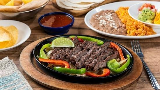 Classic Steak Fajita · Our famous fajitas are grilled over mesquite wood and served with hand-pressed flour tortillas, Pico de Gallo, cheese, mexican rice and choice of beans.
