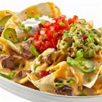 Nachos · White corn tortilla chips topped with queso, jalapeños, sour cream, guacamole, scallions and...