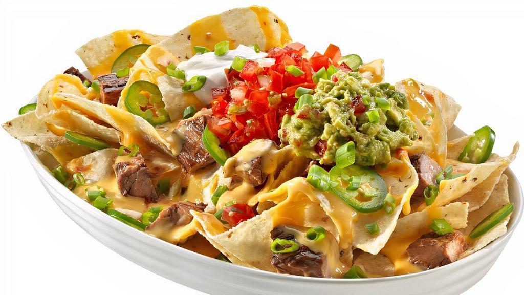 Nachos · Corn tortilla chips topped with queso, jalapenos, sour cream, guac, green onions and salsa.