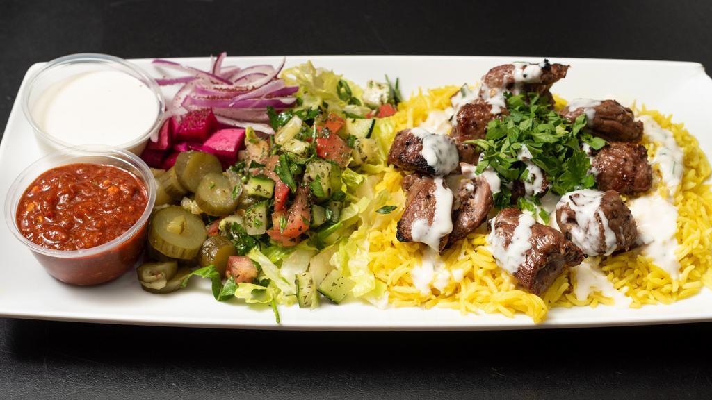Lamb Kabob Platter · Seasoned tender grilled lamb with grilled vegetables on a bed of rice.