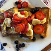Tropical French Toast · 3 french toast with fresh sliced banana, strawberries, blueberries & whipped cream.