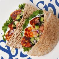Grilled Haloumi Pita · Grilled haloumi with lettuce, tomatoes, cucumber, onions, and your choice of sauce wrapped i...