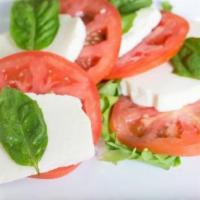 Mozzarella Caprese · Fresh Mozzarella and tomato slices served with extra virgin olive oil and fresh basil.