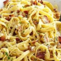 Fettuccini Carbonara · Fettuccini pasta served with bacon, onions and eggs in a cream sauce. Includes bread.