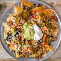 Super Nachos · TORTILLA CHIPS TOPPED WITH YOUR CHOICE OF MEAT OR VEGETARIAN, BEANS, RED ENCHILADA SOUCE, PI...