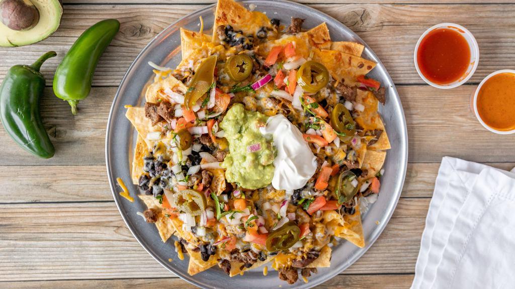 Super Nachos · TORTILLA CHIPS TOPPED WITH YOUR CHOICE OF MEAT OR VEGETARIAN, BEANS, RED ENCHILADA SOUCE, PICO DE GALLO, GUACMOLE, CHEESE, JALAPENOS AND SOUR CREA