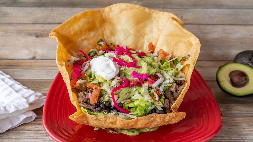Super Taco Salad · Choice of meat or vegetarian, served in a large flour tortilla shell or barefoot in a bowl. Filled with beans, rice, lettuce, tomato, pico de gallo, salsa, cheese, guacamole and sour cream.
