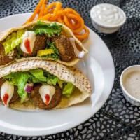 Falafel Pita · Crispy hand-shaped falafel loaded with Mediterranean spices wrapped with lettuce, tomato, hu...