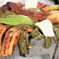 Molcajete Mexicano · For 2. Grilled chicken, steak, chorizo, salchicha, queso fresco, cambray onions, cactus leav...