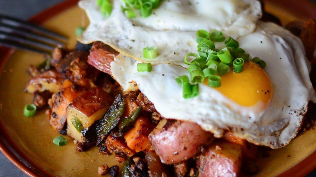 Papas Con Chorizo · griddled chorizo, sweet potatoes, golden potatoes, poblano peppers + onions topped  with fried eggs + queso fresco