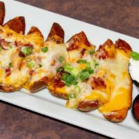 Loaded Potato Skins · Fried potato skins, colby and cheddar cheese, bacon pieces, green onion, and sour cream.