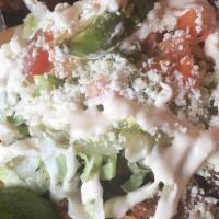 Delicious Sopes · Homemade corn tortilla topped with refried beans, your choice of meat, lettuce, tomato, Mexi...
