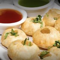 Pani Puri · Puffed crispy shells stuffed with potato, served with spicy chilled herbed broth.