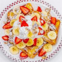 French Toast Napoleon · Three pieces of French toast with walnuts, strawberries, bananas, whipped cream and powdered...