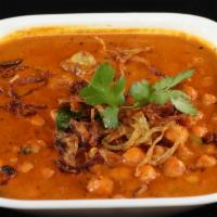 Channa Masala · Channa (chickpeas) cooked in a tomato and onion base, garnished with raw onions and cilantro.