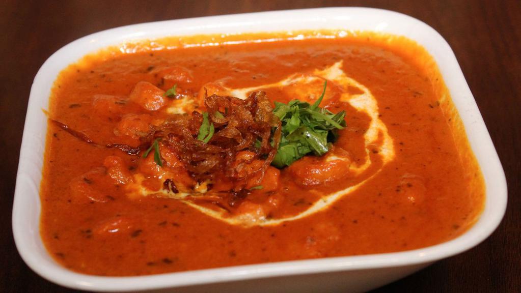 Chicken Butter Masala · Marinated chicken cooked in a mild curry base featuring butter.