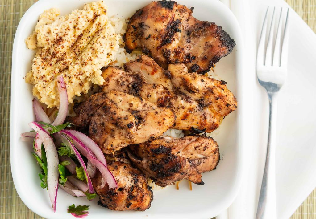 Chicken Kabob Bowl · Grilled chicken skewers marinated in yogurt, olive oil, sumac, and garlic, served over rice with a side of hummus and garlic sauce.