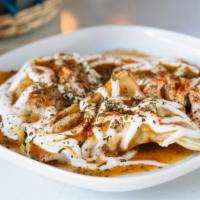 Ashak · Steamed scallion-filled dumplings, topped with yogurt and meat sauce, sprinkled with mint.