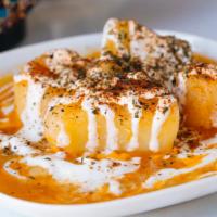 Kadu · Pumpkin cooked with tomato and onion topped with yogurt and mint.
