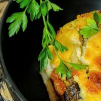 Mousaka · Layered eggplant and potato with a homemade red meat sauce and béchamel sauce.