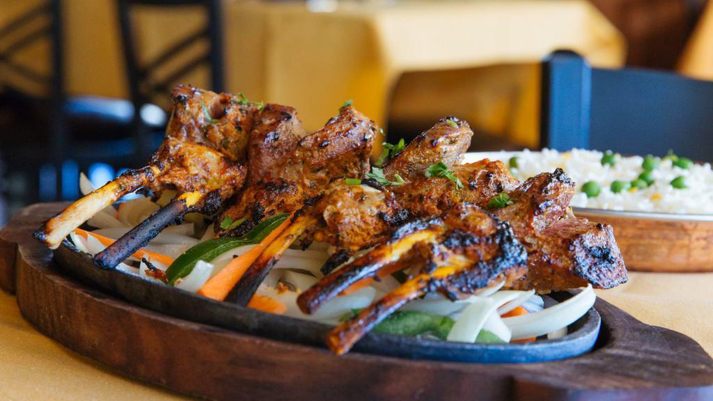 Tandoori Lamb Chops · French rack of lamb, marinated with sour scream and spices and grilled in the tandoor oven. Served with saffron basmati rice and mango chutney.